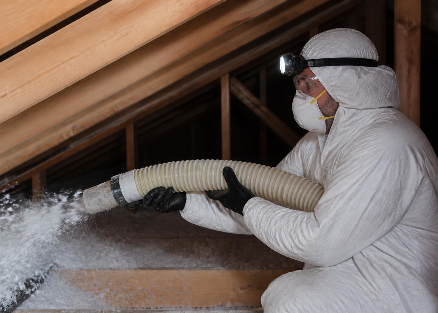 Energy Experts technician installing blown-in attic insulation